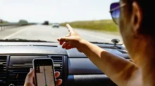 Žena naviguje v autě pomocí telefonu