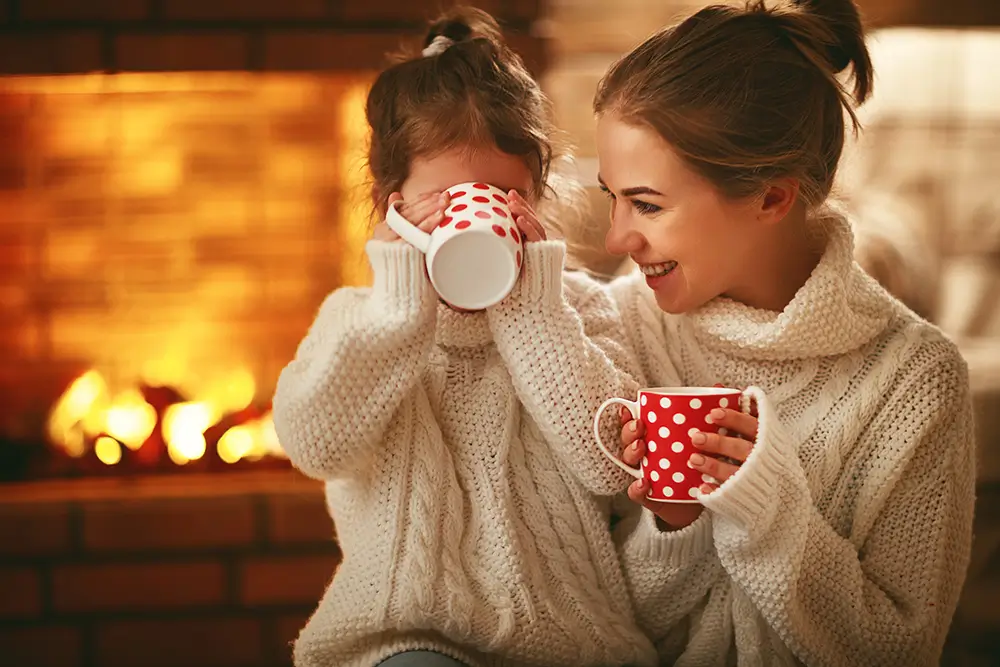 Pití kakaa odbourává stres, navozuje pocit pohody, štěstí a bezpečí. - Techsvět maminka s dcerou popíjejí kakao u krbu