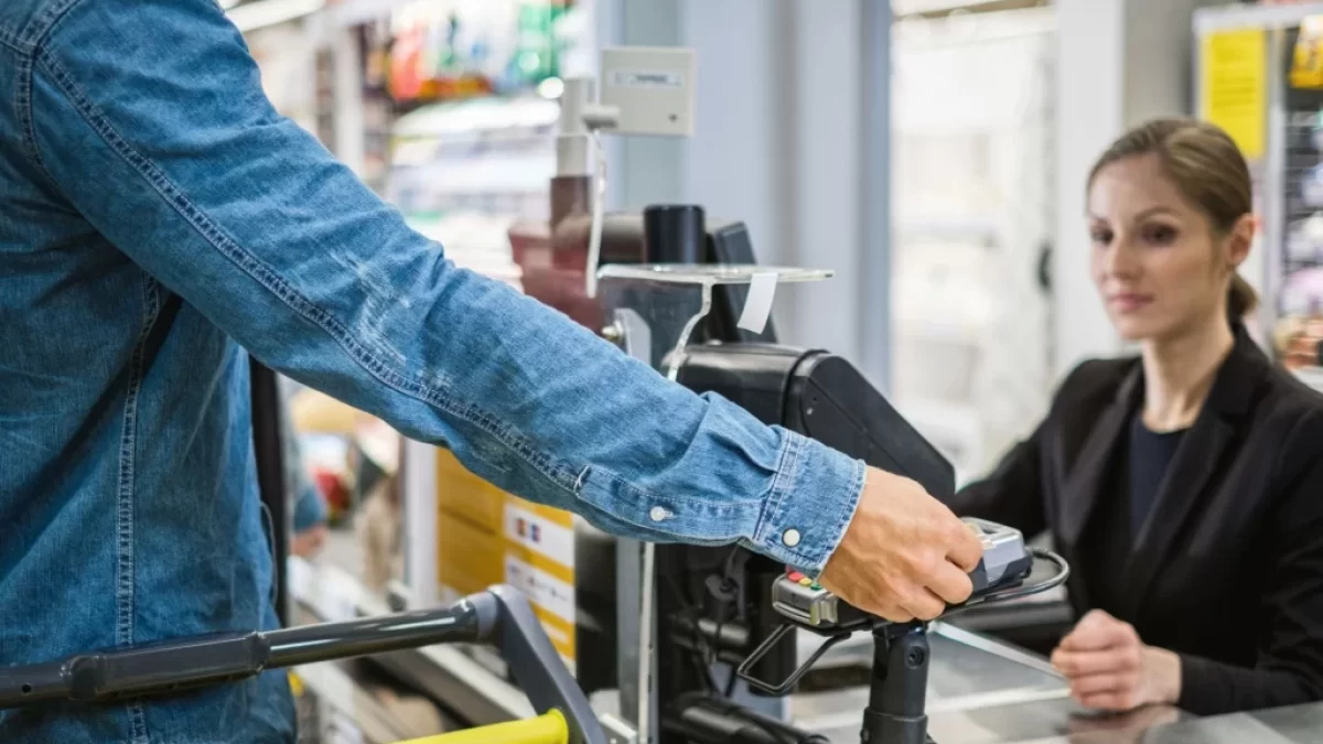 zákazník v supermarketu platí kartou prodavačce