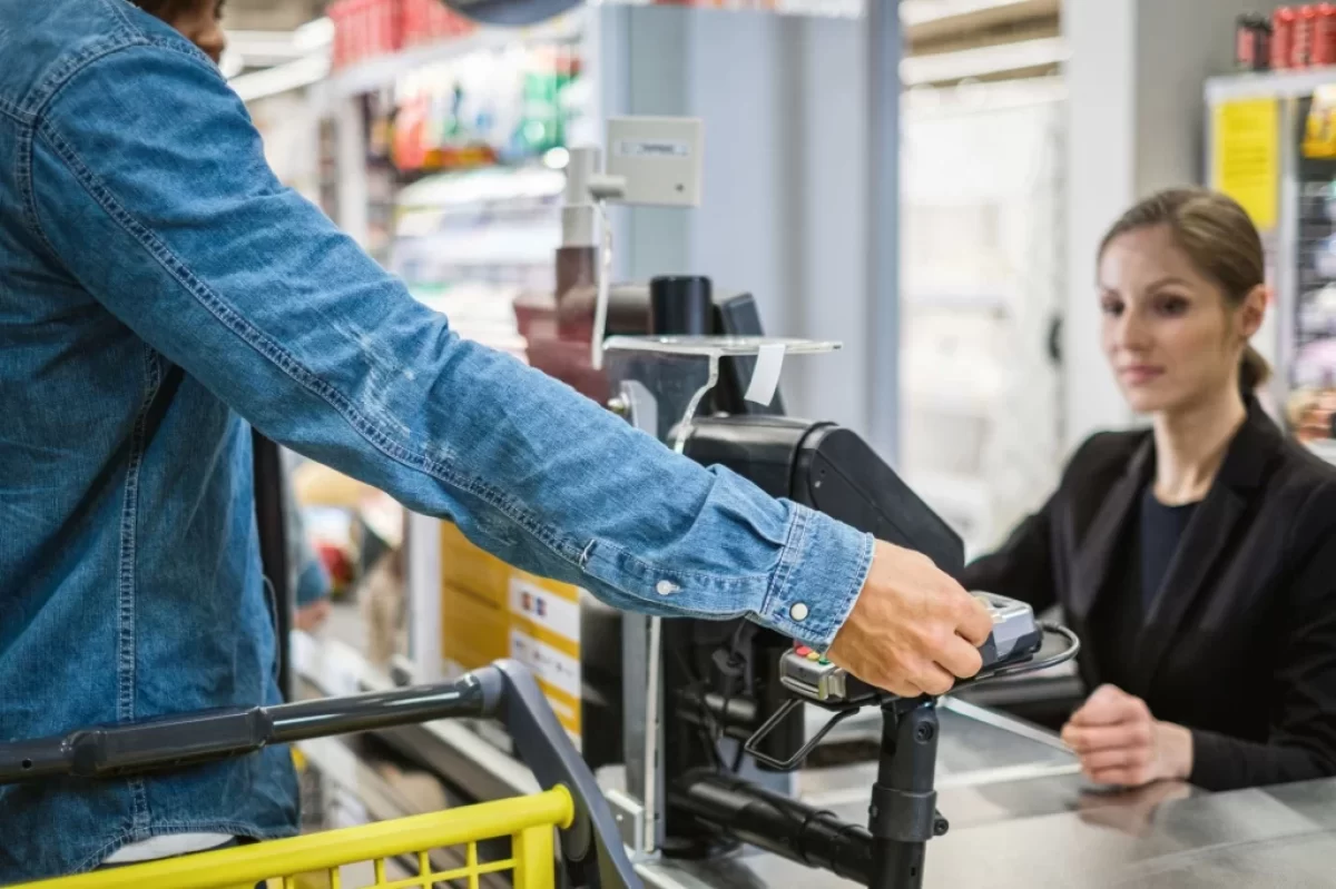 zákazník v supermarketu platí kartou prodavačce
