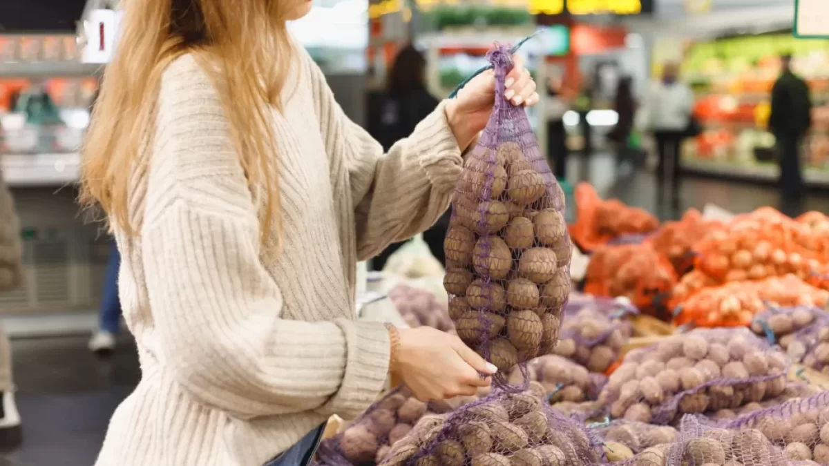 žena vybírá v obchodě brambory