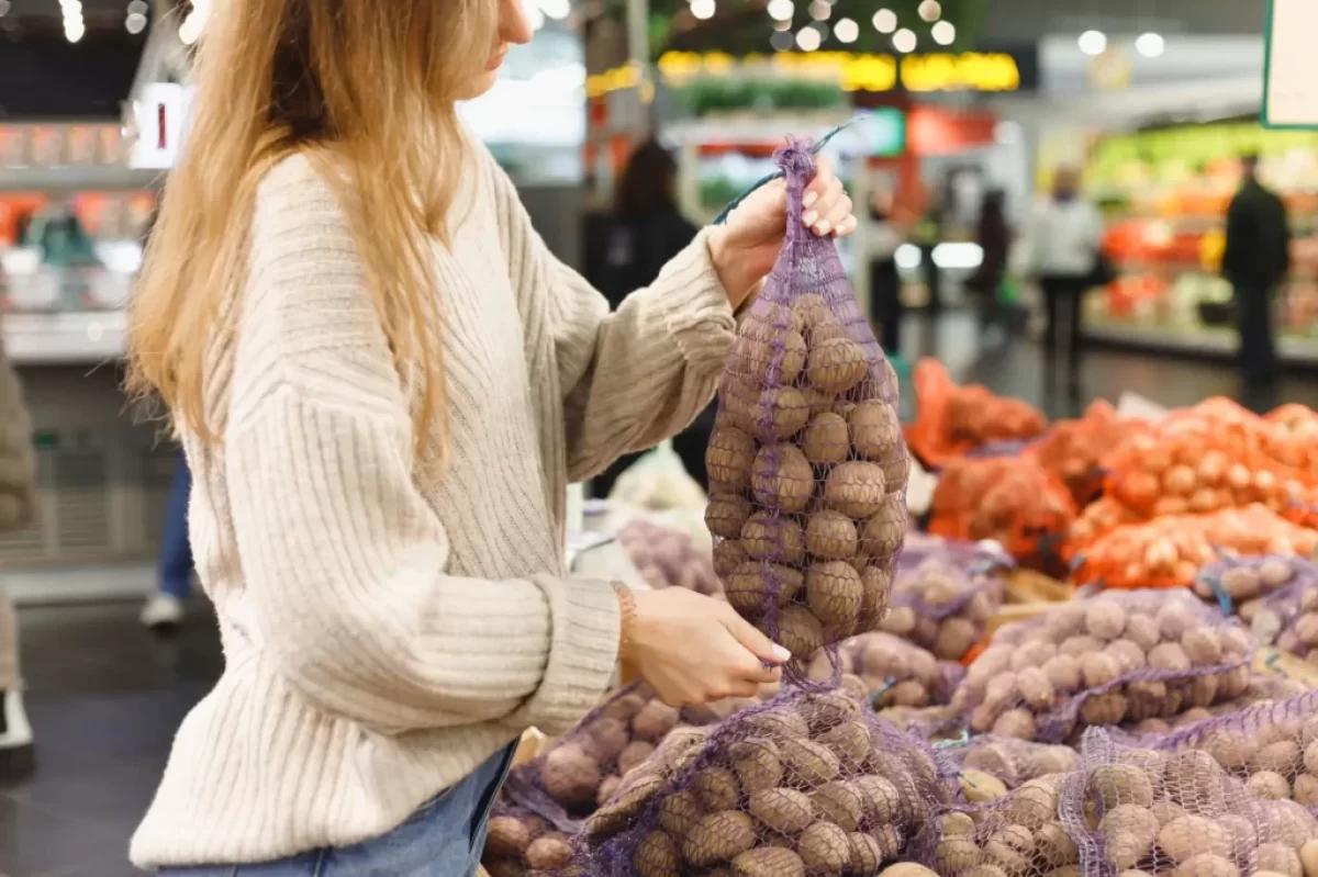 žena vybírá v obchodě brambory