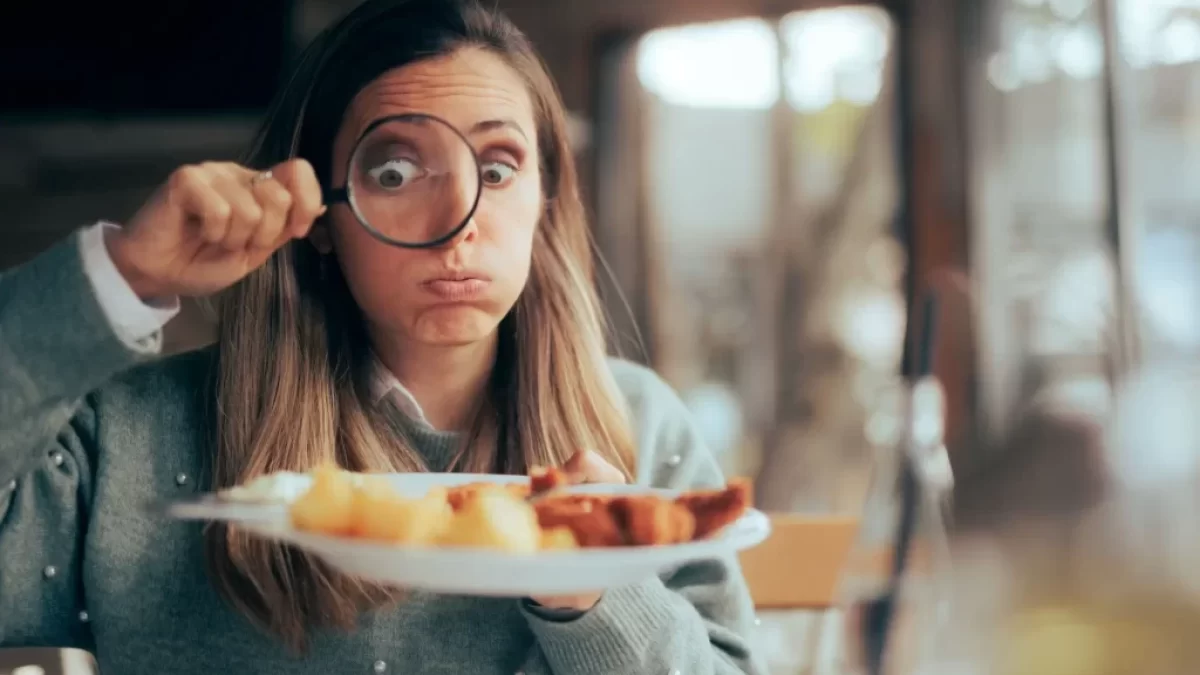 žena zkoumá své jídlo pod lupou