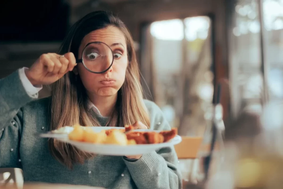 žena zkoumá své jídlo pod lupou
