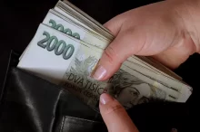 žena dává peníze do peněženky