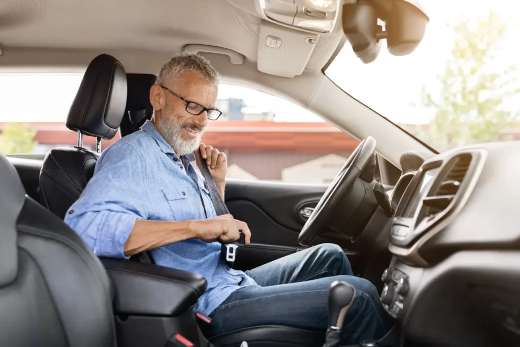 Shutterstock_2370679143 - Techsvět Muž senior si zapíná pásy, aby mohl odjet autem