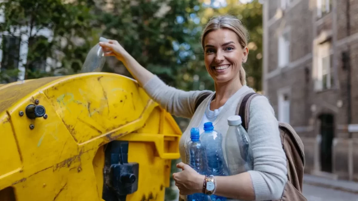 Žena vyhazuje plast do kontejneru
