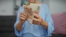 starší žena drží české bankovky