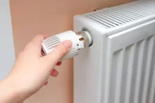 Člověk reguluje teplotu na topení