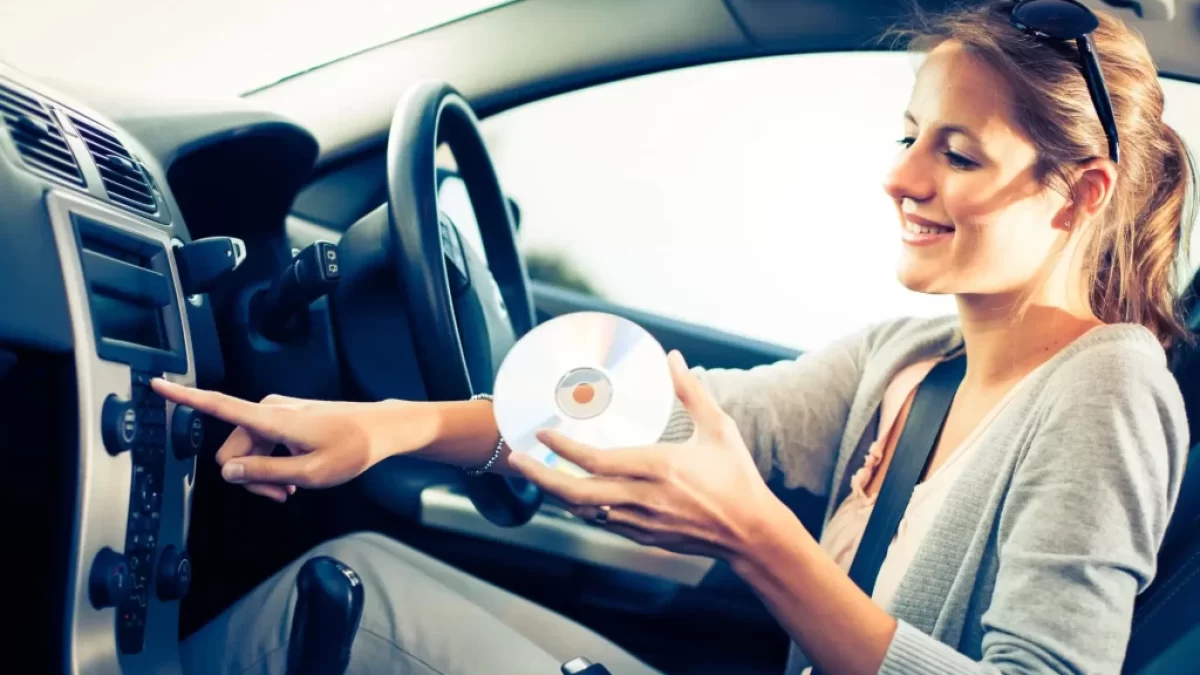 Žena si pouští CD v autě