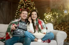 Pár se dívá na televizi o Vánocích