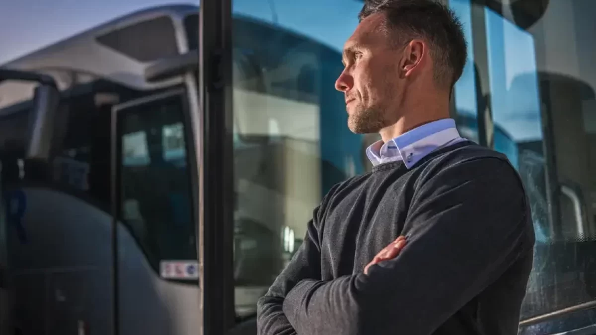 Řidič autobusu stojící u otevřených dveří