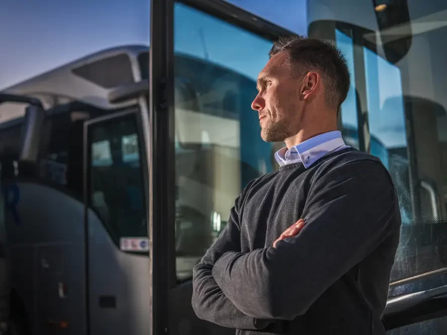 Řidič autobusu stojící u otevřených dveří