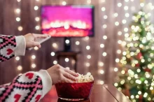 Žena se o Vánocích dívá na televizi