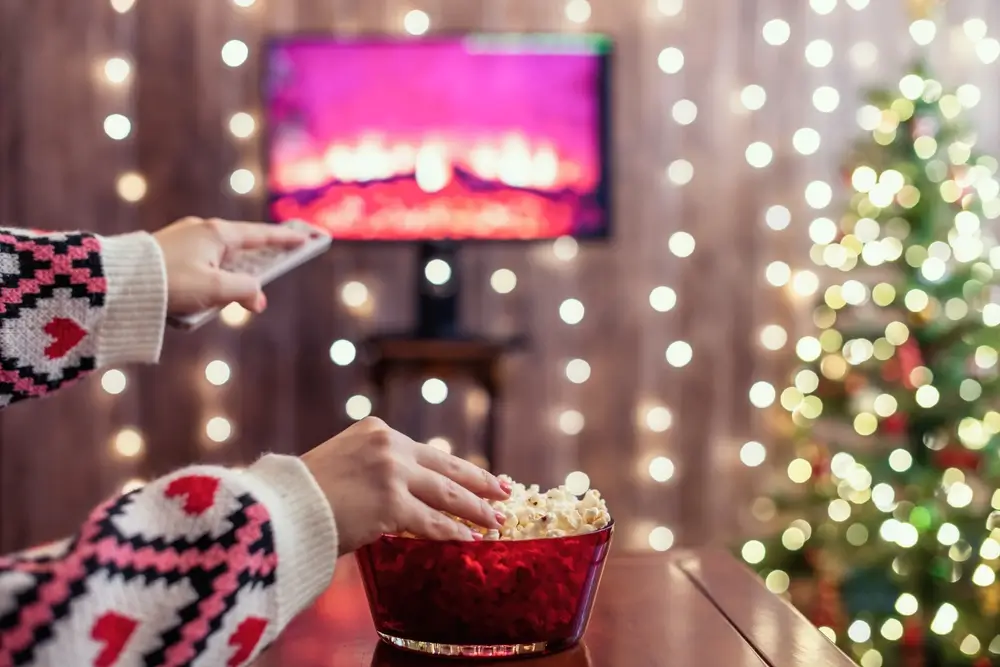 Žena se o Vánocích dívá na televizi