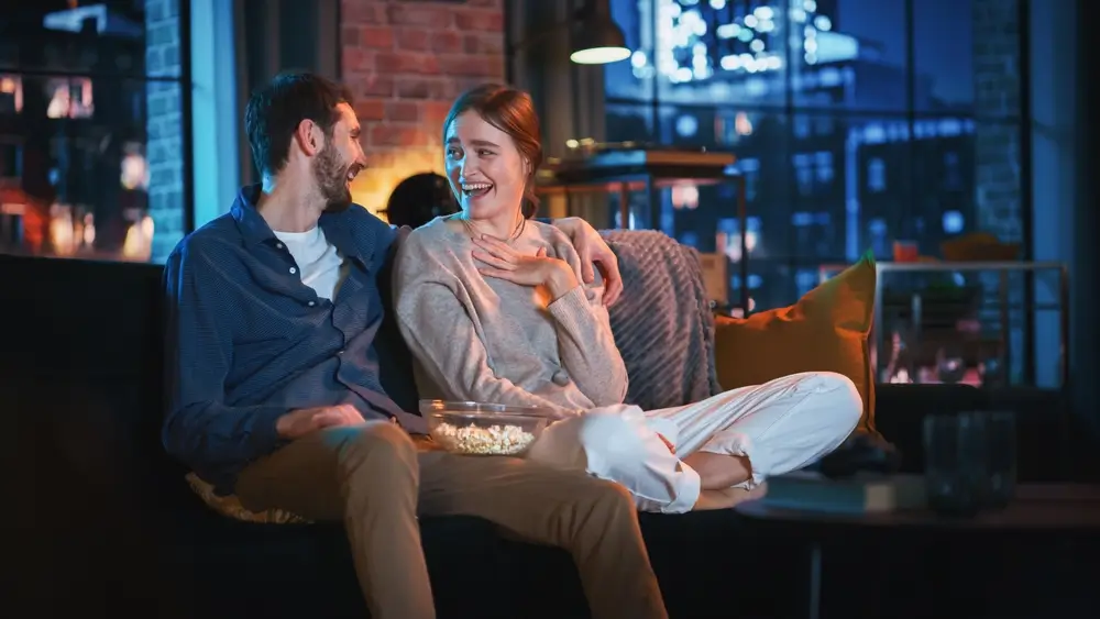 Žena a muž se smějí u televize