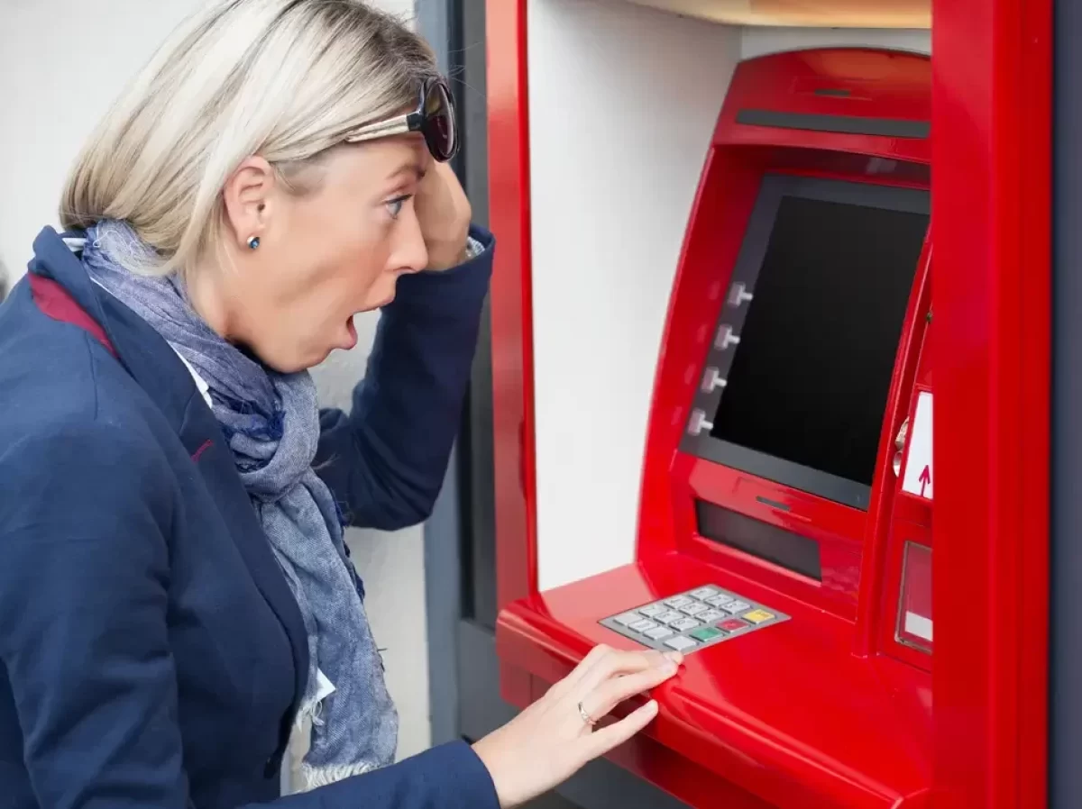 Divící se žena u bankomatu