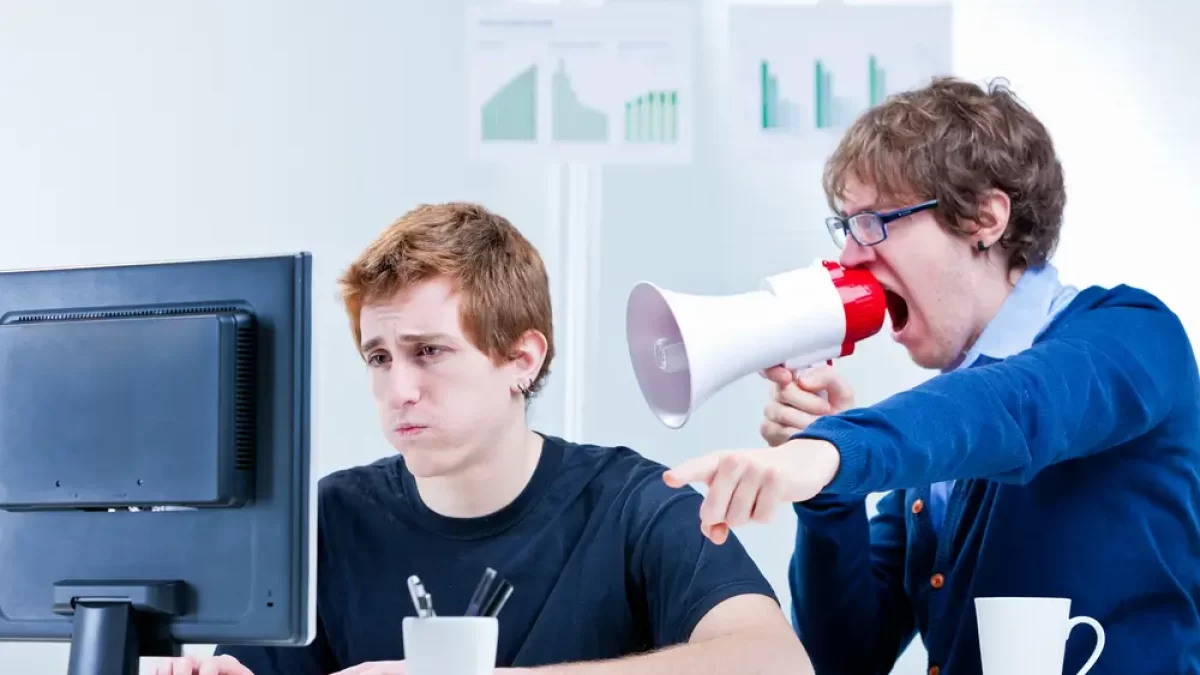 muž křičí do megafonu na jiného muže