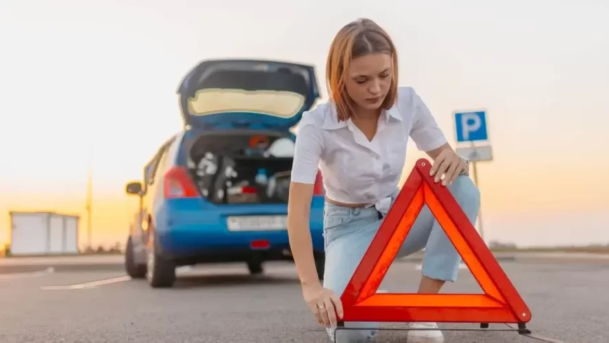 Žena umisťující výstražný trojúhelník
