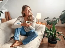 Žena si užívá šálek kávy na gauči