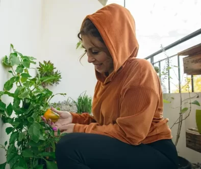 Žena na balkoně pěstující papriku