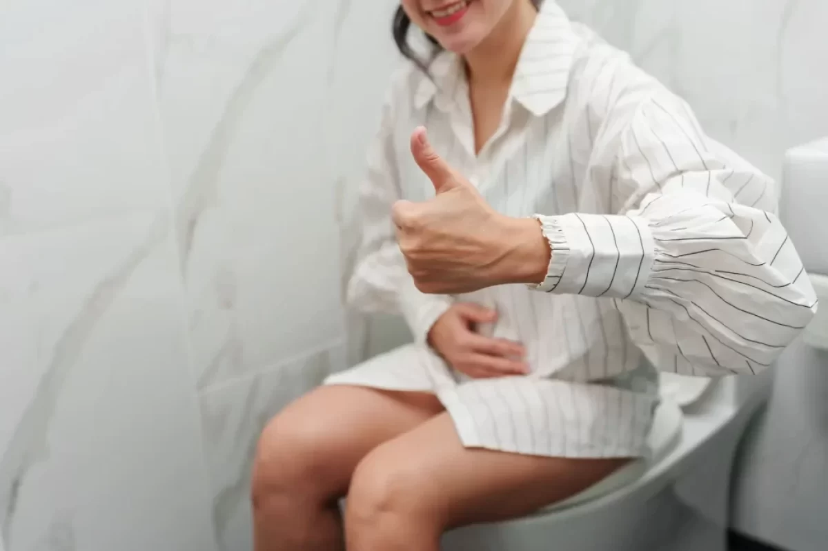 Žena sedí na záchodě