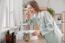 žena si čistí zuby v koupelně