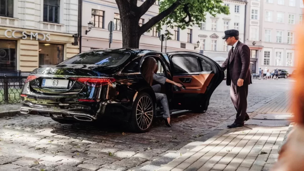 žena vystupuje z mercedesu, který jí otevírá řidič