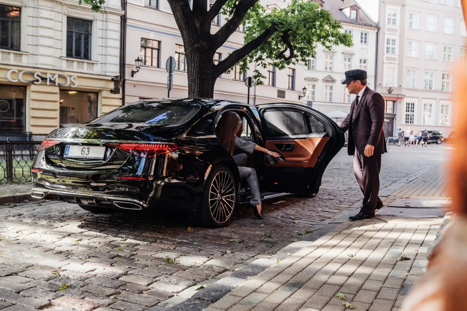 žena vystupuje z mercedesu, který jí otevírá řidič