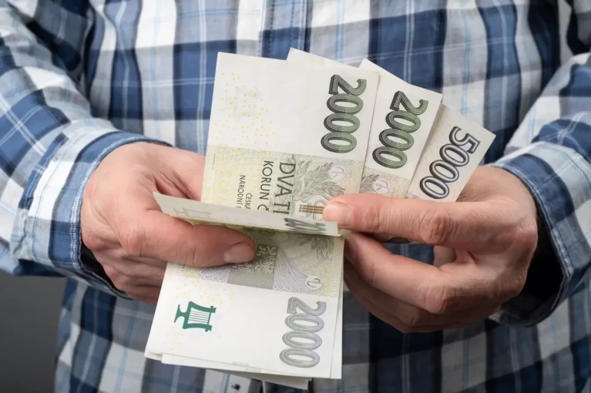 muž počítá české peníze