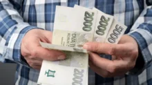 muž počítá české peníze