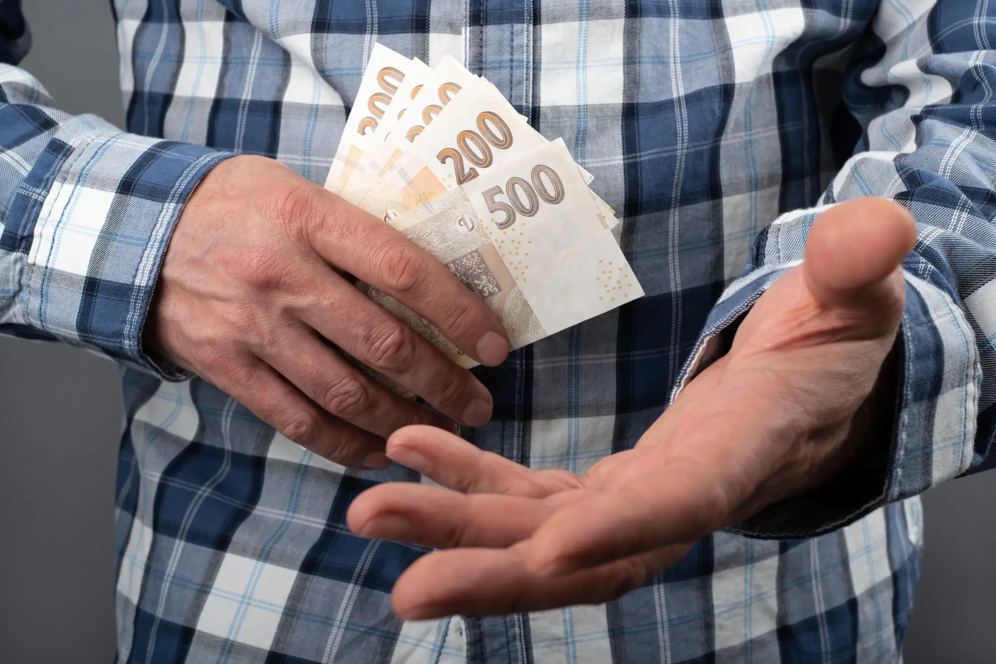 muž s českými bankovkami v ruce