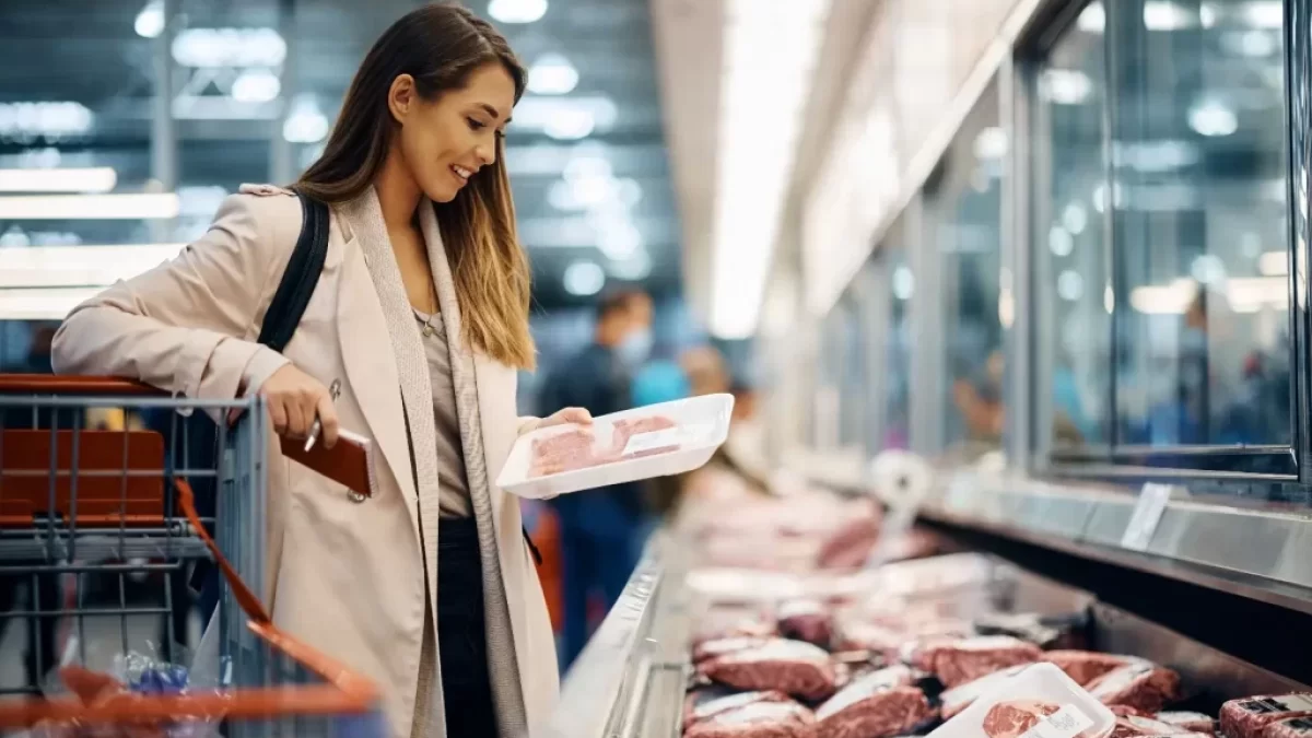 žena si v supermarketu vybírá maso