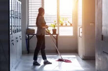 Uklízečka ve škole vytírá podlahu