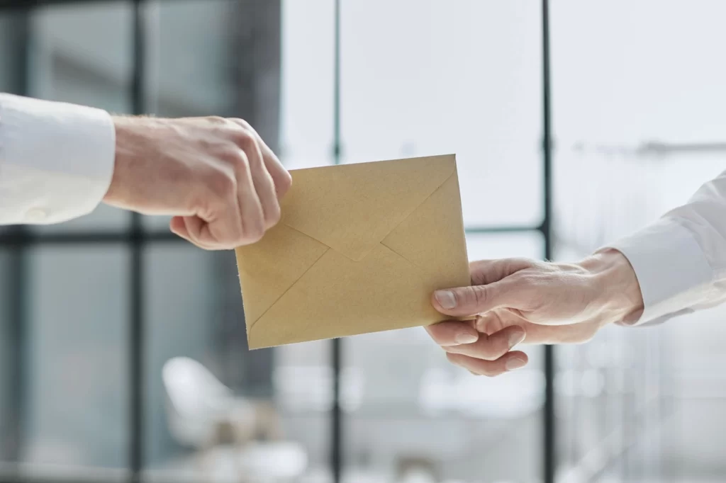 Kdy jsou dary osvobozeny od daně? Pokud jste příbuzní, tak ano. Zdroj: Shutterstock - Techsvět předávání obálky z ruky do ruky