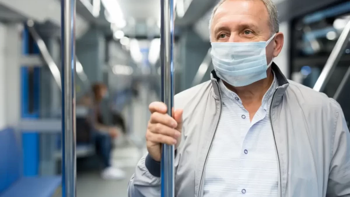 Muž ve veřejné dopravě nosí roušku