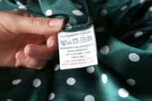 Ženská ruka drží cedulku na oblečení