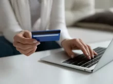 Žena zadává údaje z karty do laptopu
