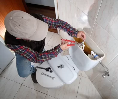 Muž opravuje WC