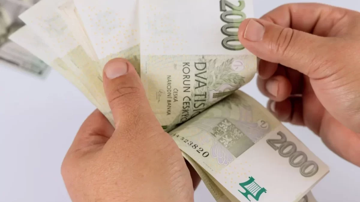 Muž drží v ruce dvoutisícovky