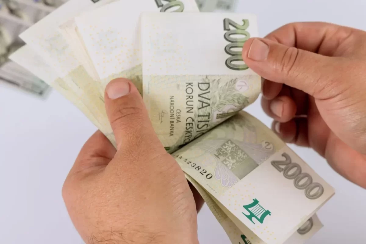 Muž drží v ruce dvoutisícovky