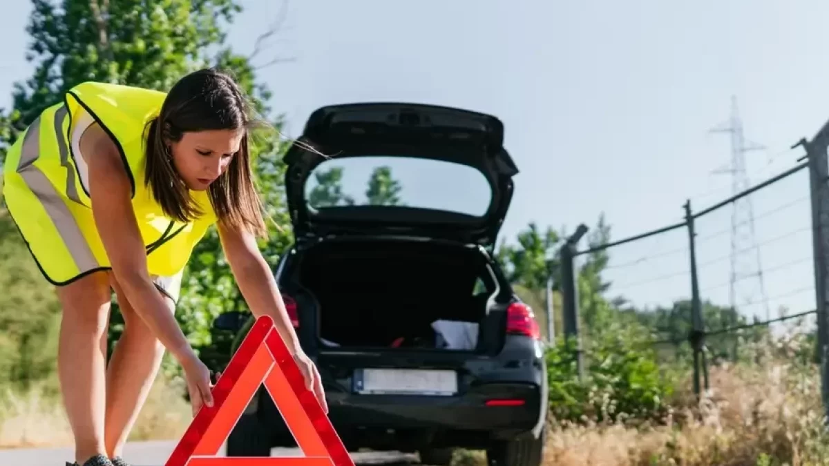 žena dává výstražný trojúhelník za auto