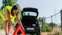 žena dává výstražný trojúhelník za auto