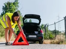 žena dává výstražný trojúhelník za auto