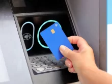 ruka s kartou u bankomatu