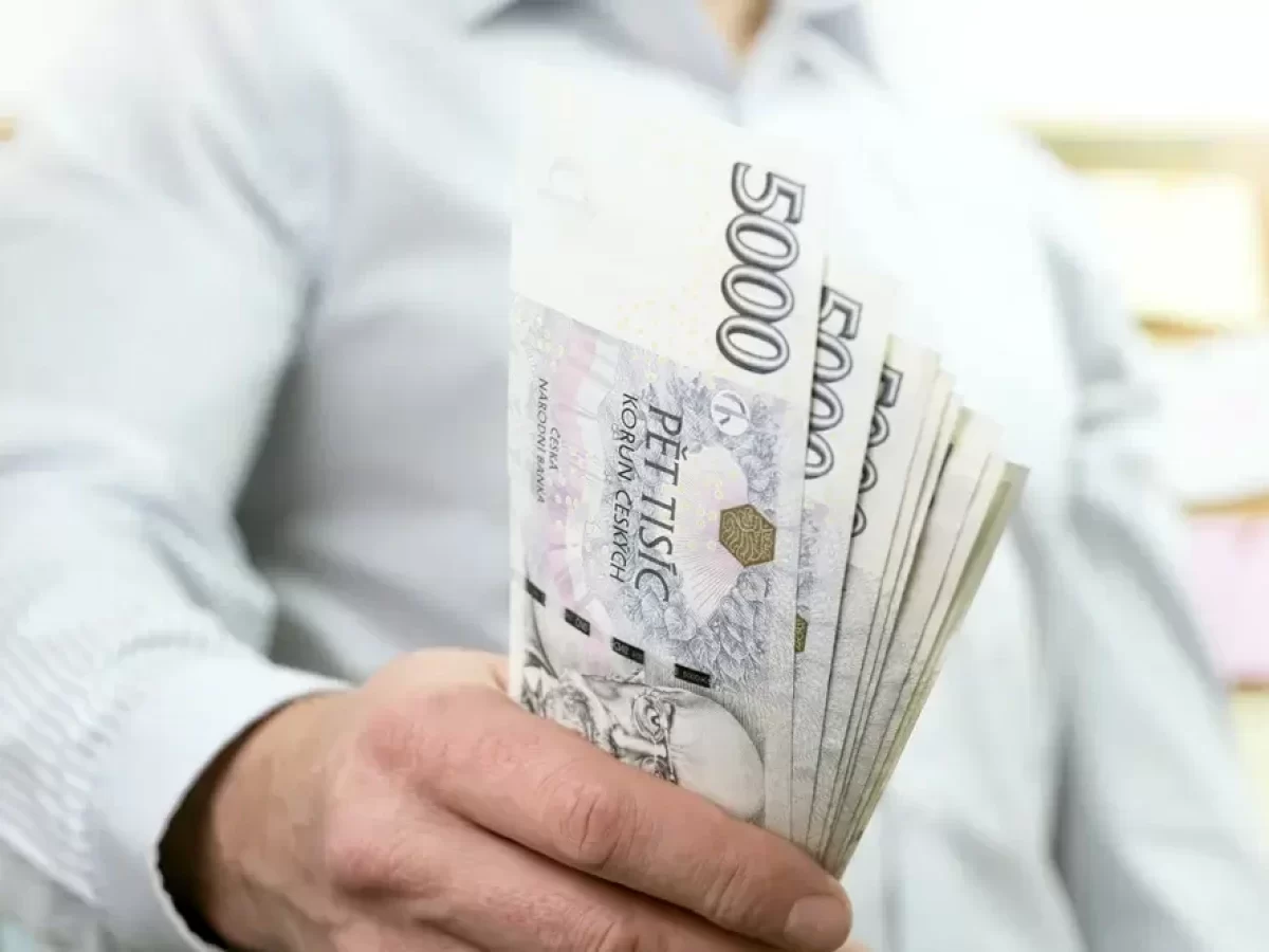 Muž drží pětitisícové bankovky