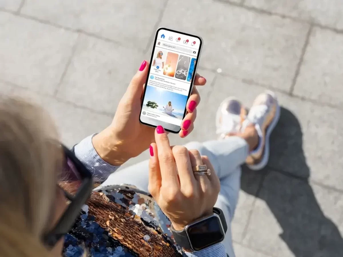 Žena kouká na facebook na smartphonu