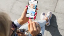 Žena kouká na facebook na smartphonu