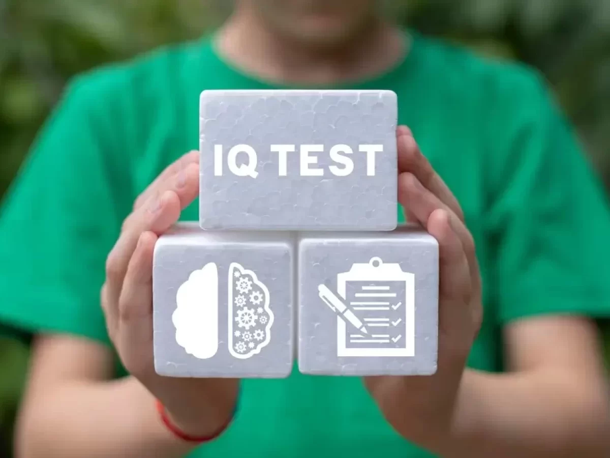 Muž drží kostičky s nápisem IQ test