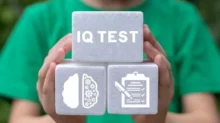 Muž drží kostičky s nápisem IQ test